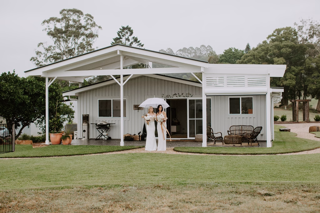 Couple getting married standing in from of Heartwood Farm Byron Bay
